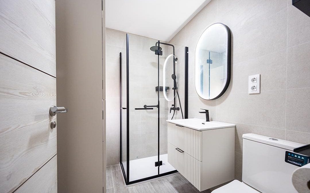 Un baño moderno en tonos neutros con detalles en negro.